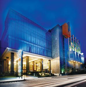 ein großes Glasgebäude mit blauem Licht in der Unterkunft Golden Flower by KAGUM Hotels in Bandung