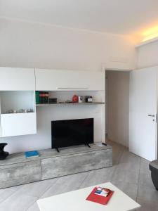ein Wohnzimmer mit einem TV und einem Sofa in der Unterkunft Appartamento sul porto in Loano