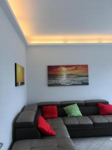 ein Wohnzimmer mit einem braunen Sofa und bunten Kissen in der Unterkunft Appartamento sul porto in Loano