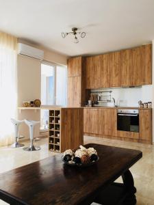 kuchnia z drewnianymi szafkami i drewnianym stołem w obiekcie Molly's Suite w mieście Sofia