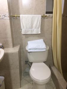 y baño con aseo, lavabo y toallas. en Casa Vista Hermosa Quito, en Quito