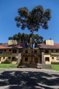 a large building with a tree in front of it at Estalagem Vila Suzana - Quadra de Beach Tennis Indoor in Canela