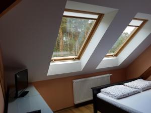 a bedroom with two windows and a bed with a television at Willa Reverans in Borne Sulinowo