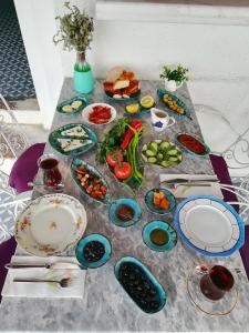 a table with plates and bowls of food on it at Cunda Mavi Hotel in Ayvalık +17 photos
