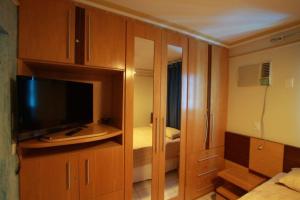 Habitación con TV y habitación con cama en Condominio Millenium Thermas Residence, en Caldas Novas
