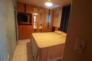 Dormitorio pequeño con cama y TV en Condominio Millenium Thermas Residence, en Caldas Novas