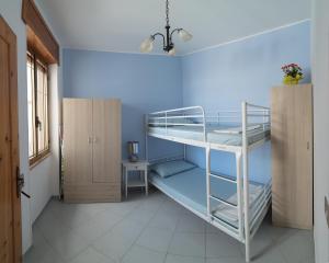 リド・マリーニにあるAppartamento Pesceの青い壁のドミトリールームの二段ベッド1台分です。
