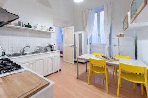 a kitchen with a table and yellow chairs in a kitchen at Rental in Rome - Bramante Luxury in Rome