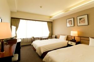 Postel nebo postele na pokoji v ubytování Ryukyu Sun Royal Hotel