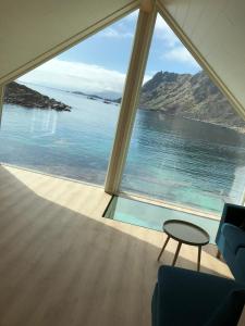 Zimmer mit einem großen Fenster und Meerblick in der Unterkunft Fisherman`s Cabin Lofoten in Ballstad