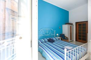1 dormitorio con 1 cama con pared azul en Camera Con Vista Apartments, en Nápoles