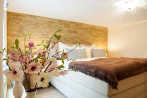 クヴェードリンブルクにあるFerienhaus Schlossgartenの花瓶に花が飾られたベッドのある寝室