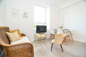 een woonkamer met een tafel en stoelen en een televisie bij Stafford Modern Apartment in Aberdeen