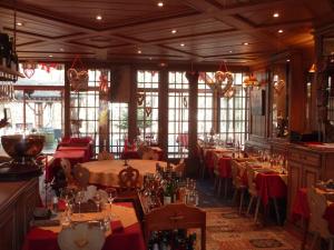 a dining room with tables and chairs and windows at Hotel Restaurant Les Pins logis in Haguenau