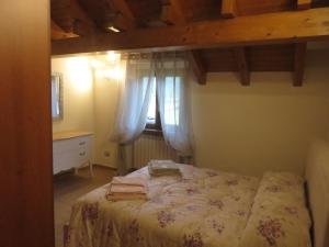 Schlafzimmer mit einem Bett und einem Fenster in der Unterkunft La Palma in Domodossola