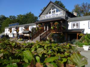 un gran edificio blanco con plantas delante en Hotel Restaurant Les Pins logis, en Haguenau