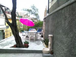 a patio with a table with a pink umbrella at Casa dell'ulivo in Moneglia +28 photos