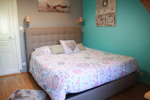 アンボワーズにあるSur les toits d'Amboiseのベッドルーム1室(ピンクと白の掛け布団付きのベッド1台付)