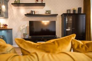 a living room with a couch and a tv at Mosel-Suiten in Cochem
