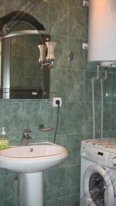 a bathroom with a sink and a washing machine at Однокомнатная квартира у моря in Gagra