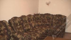 a couch in the corner of a room at Однокомнатная квартира у моря in Gagra