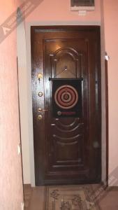 a large wooden door with a spiral painted on it at Однокомнатная квартира у моря in Gagra
