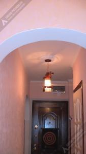 a hallway with a door with a light and a ceiling at Однокомнатная квартира у моря in Gagra
