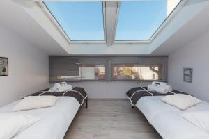 eine Reihe von Betten in einem Zimmer mit Dachfenster in der Unterkunft Loft 3 pièces duplex 3 étoiles calme centre ville à 5 mn des plages et palais in Cannes