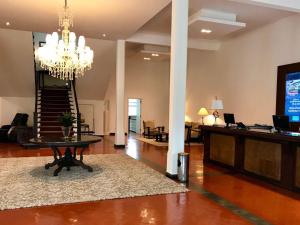 a living room with a table and a chandelier at Hotel Escola Bela Vista in Volta Redonda