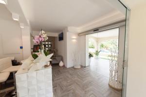 a living room with a glass door and flowers at Suimi's Hotel in Villasimius