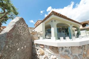 a building at the resort with a stone wall at Suimi's Hotel in Villasimius