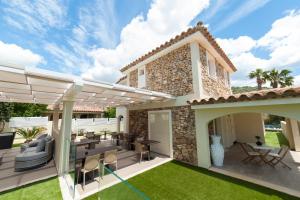 a patio with a table and chairs under a pergola at Suimi's Hotel in Villasimius