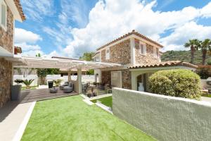 a house with a yard with green grass at Suimi's Hotel in Villasimius
