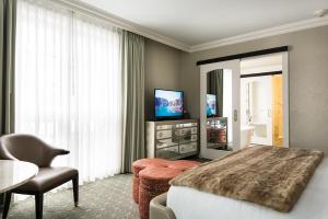 um quarto de hotel com uma cama e uma televisão em Delamar West Hartford em West Hartford