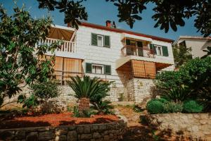 a house with a balcony and some plants at Apartments Doulos in Splitska