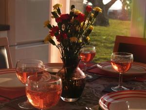 una mesa con un jarrón de flores y copas de vino en Sunny View, 87 Brambles Chine, en Freshwater