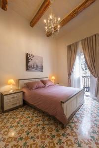 a bedroom with a large bed and a chandelier at Amelie in Rabat