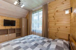 1 dormitorio con paredes de madera, 1 cama y TV en Zolota Rybka en Skhidnitsa
