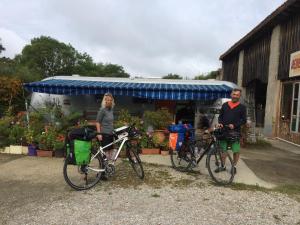 two people standing with their bikes in front of a store at Belrepayre Airstream Camp in Manses