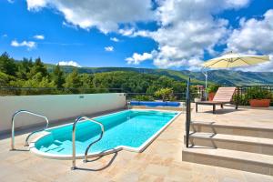 a swimming pool with a view of a mountain at Kalina Deluxe Apartments in Jelsa