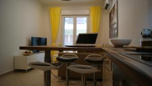 cocina con barra con taburetes y ordenador portátil en Brand New Luxury Apartment, en Tesalónica