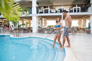 a man and a woman are standing in a swimming pool at Sugar Bay Barbados - All Inclusive in Bridgetown