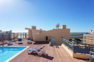 a house with a swimming pool on top of a deck at Appartement de Charme in Olhão