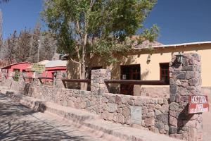 a stone retaining wall in front of a building at Hostal Paseo de los Colorados in Purmamarca