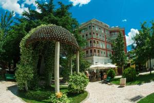 a garden with a large umbrella in front of a building at City Centre Apartment 1 in Shkodër