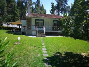 a house with a pathway in front of a yard at Nirvana house in Sani Beach