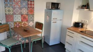 a small kitchen with a table and a refrigerator at Appartment Fasanenhof Klinikum und Uni nah mit Netflix in Kassel