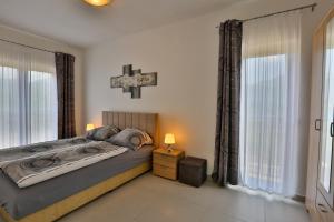 a bedroom with a bed and a cross on the wall at Kristina Apartments in Tivat