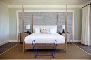 a bedroom with a large white bed and a chair at The Island House in Nassau