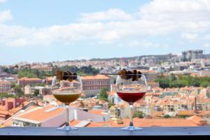 twee glazen wijn bovenop een tafel bij The Sunset Nest in Lissabon